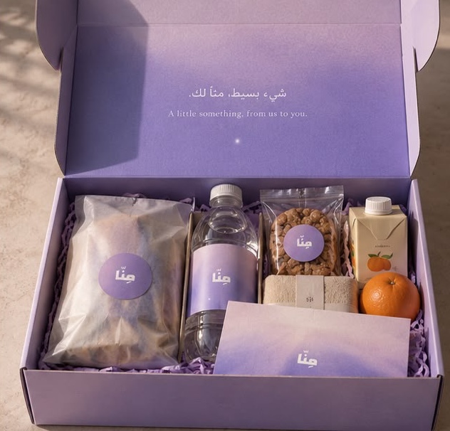 An open MINNA thank-you box with snacks, water and a card